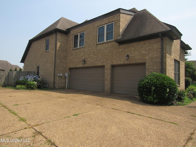 3542 Marcia Louise Dr, Southaven, MS 38672 - view of side of property with brick siding, an attached garage, concrete driveway, and a shingled roof