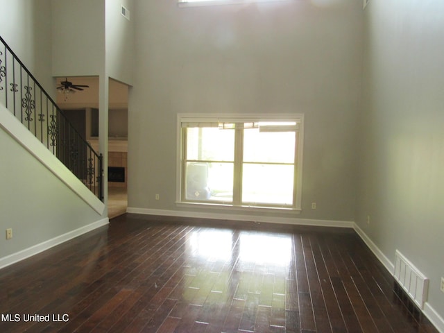 3542 Marcia Louise Dr, Southaven, MS 38672 - unfurnished living room with stairway, dark wood-style flooring, a high ceiling, and a ceiling fan