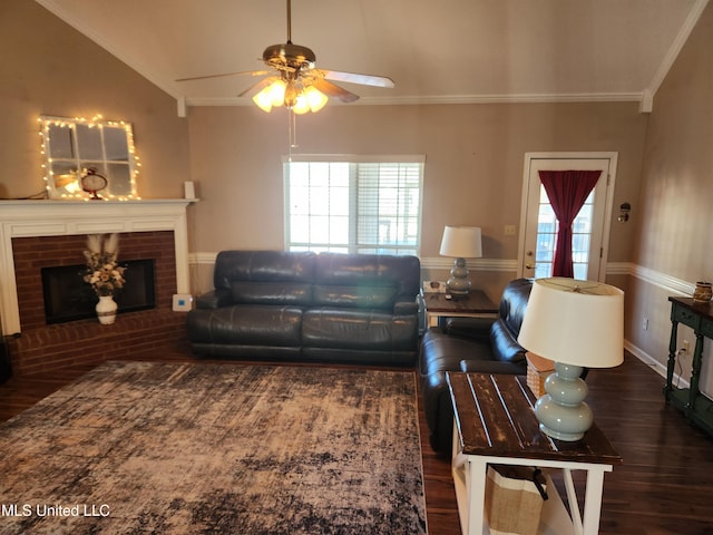 living room featuring a fireplace, lofted ceiling, ornamental molding, a ceiling fan, and wood finished floors