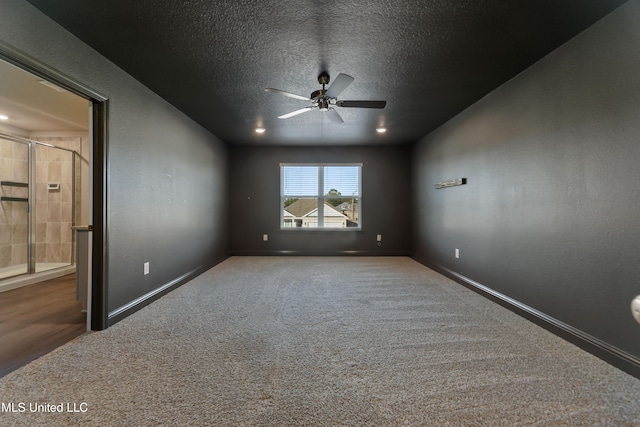 carpeted spare room featuring a textured ceiling and ceiling fan