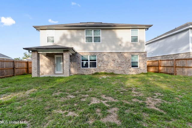 rear view of property with a yard