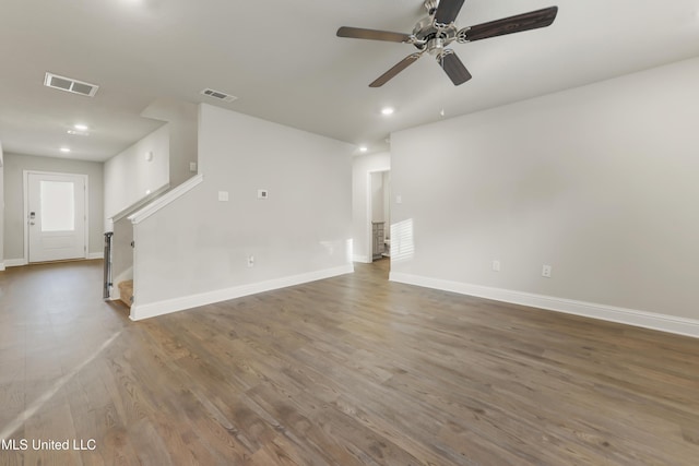 unfurnished living room featuring ceiling fan and dark hardwood / wood-style flooring