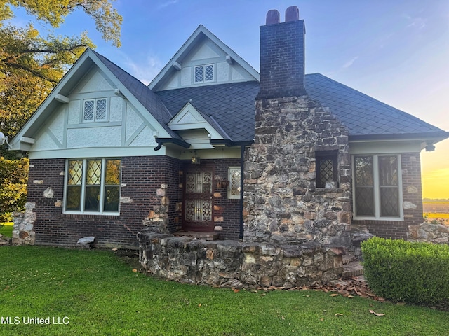 5228 Old Hwy 49, Clarksdale, MS 38614 - tudor house with a chimney, a lawn, and brick siding