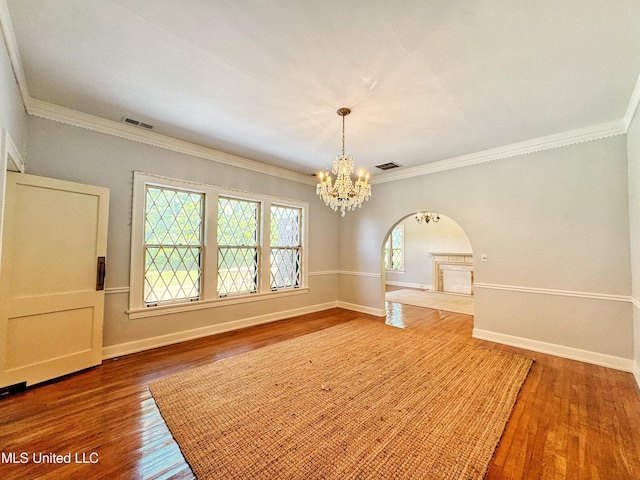 5228 Old Hwy 49, Clarksdale, MS 38614 - spare room featuring wood finished floors, a chandelier, arched walkways, ornamental molding, and baseboards