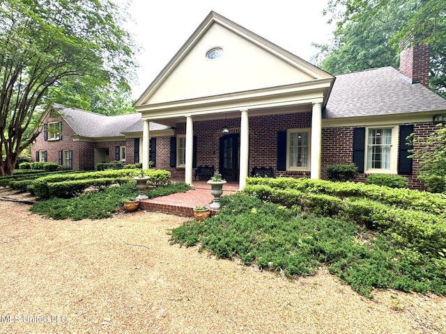 59 Dunbar Rd, Natchez, MS 39120 - neoclassical / greek revival house with brick siding, a chimney, roof with shingles, and stucco siding
