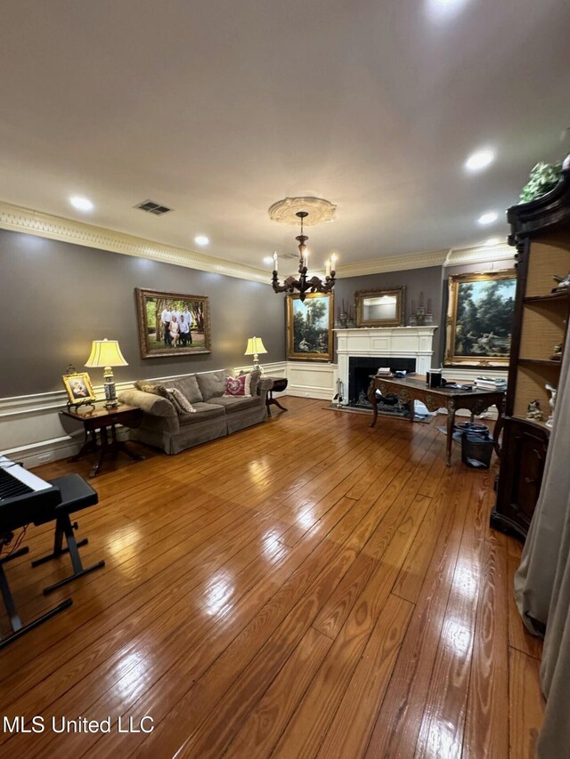 59 Dunbar Rd, Natchez, MS 39120 - living room featuring crown molding, a fireplace, hardwood / wood-style flooring, and a chandelier