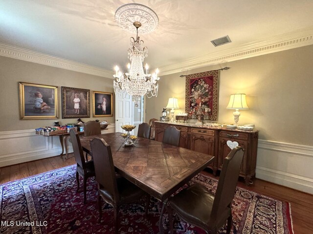 59 Dunbar Rd, Natchez, MS 39120 - dining room featuring wood finished floors, a chandelier, crown molding, and a wainscoted wall