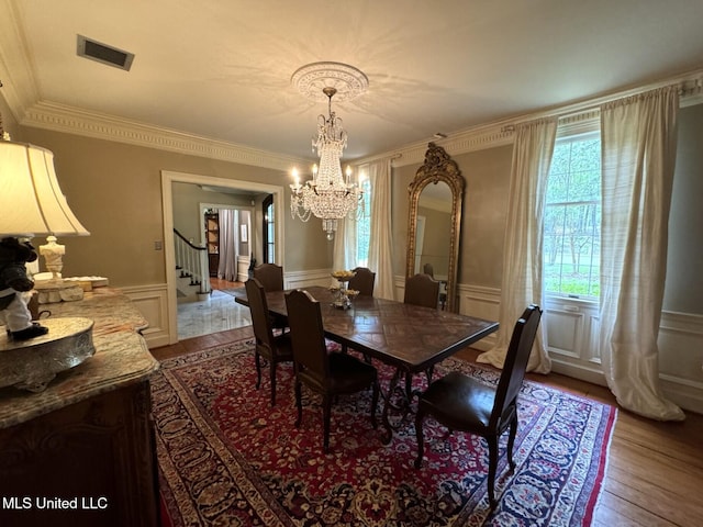 59 Dunbar Rd, Natchez, MS 39120 - dining space featuring a chandelier, stairs, plenty of natural light, light wood-style floors, and a decorative wall