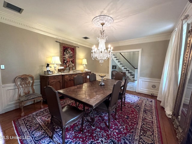 59 Dunbar Rd, Natchez, MS 39120 - dining area featuring dark wood-style floors, stairs, a chandelier, a decorative wall, and ornamental molding