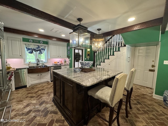 59 Dunbar Rd, Natchez, MS 39120 - kitchen with a sink, stainless steel dishwasher, brick flooring, white cabinets, and recessed lighting