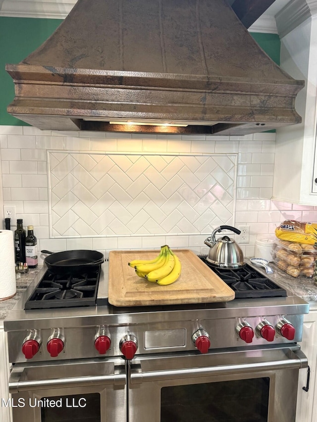 59 Dunbar Rd, Natchez, MS 39120 - kitchen with custom range hood, backsplash, range with two ovens, light countertops, and crown molding