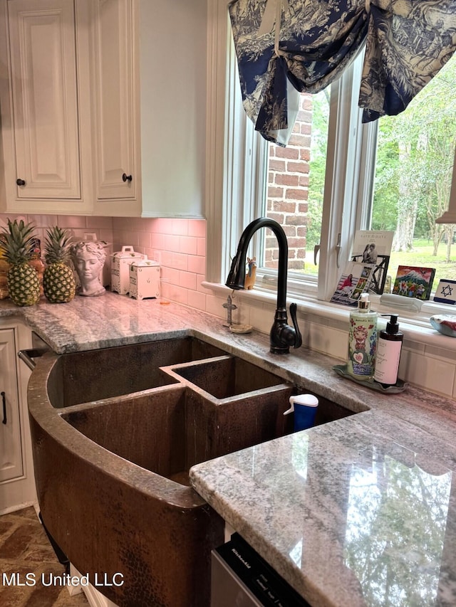 59 Dunbar Rd, Natchez, MS 39120 - kitchen with light stone countertops, decorative backsplash, and a sink