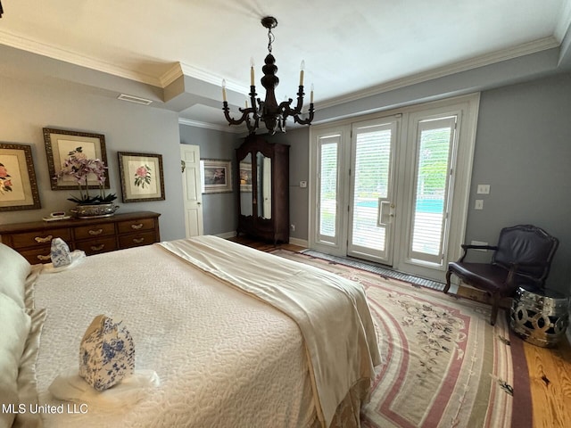 59 Dunbar Rd, Natchez, MS 39120 - bedroom with a chandelier, access to exterior, crown molding, wood finished floors, and baseboards