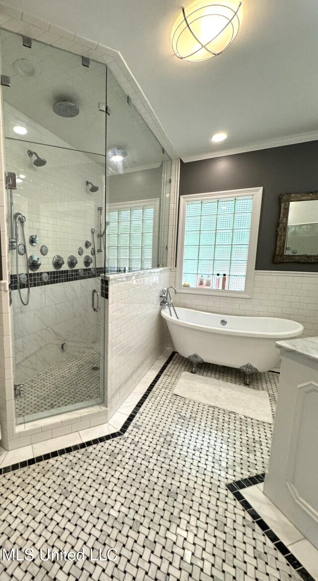 59 Dunbar Rd, Natchez, MS 39120 - full bath featuring tile walls, a stall shower, a soaking tub, ornamental molding, and a wainscoted wall