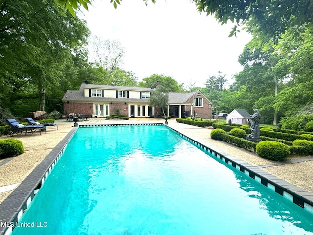 59 Dunbar Rd, Natchez, MS 39120 - outdoor pool with french doors, a patio area, and view of wooded area
