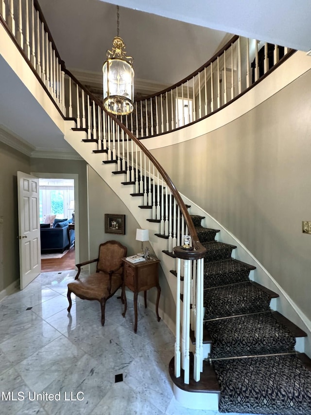 59 Dunbar Rd, Natchez, MS 39120 - stairway with ornamental molding, baseboards, a chandelier, marble finish flooring, and a high ceiling