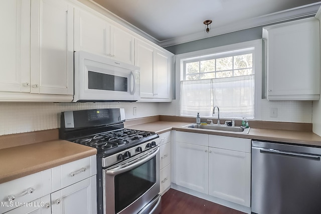 kitchen featuring white cabinetry, stainless steel appliances, sink, and backsplash