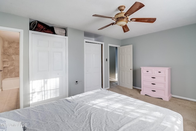 bedroom featuring light carpet, ensuite bath, and ceiling fan