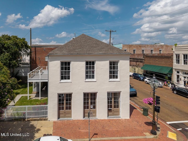 433 Main St, Natchez, MS 39120 - rear view of house with a shingled roof, stucco siding, and a balcony