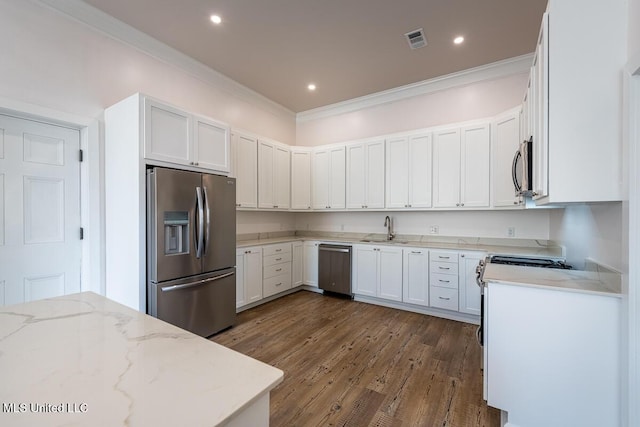 433 Main St, Natchez, MS 39120 - kitchen with appliances with stainless steel finishes, crown molding, light stone counters, dark wood finished floors, and white cabinetry