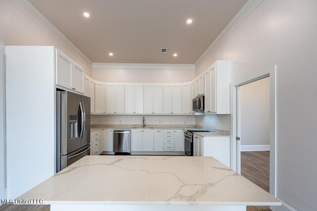 433 Main St, Natchez, MS 39120 - kitchen with appliances with stainless steel finishes, ornamental molding, light stone counters, recessed lighting, and wood finished floors