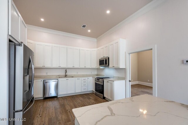 433 Main St, Natchez, MS 39120 - kitchen featuring stainless steel appliances, crown molding, light stone counters, dark wood-style flooring, and recessed lighting