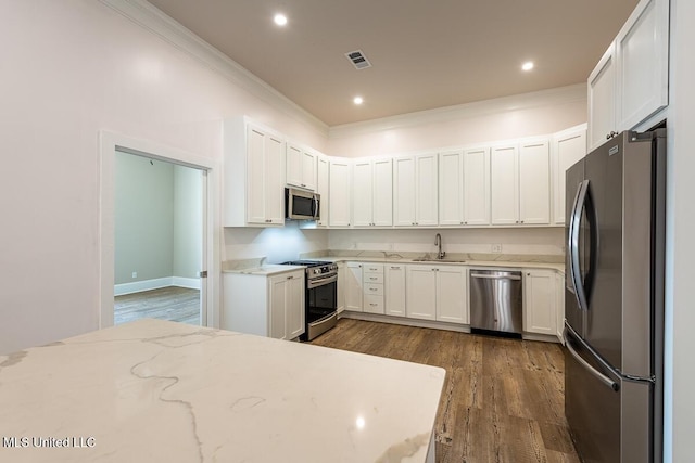433 Main St, Natchez, MS 39120 - kitchen with appliances with stainless steel finishes, crown molding, dark wood-style flooring, light stone counters, and white cabinets