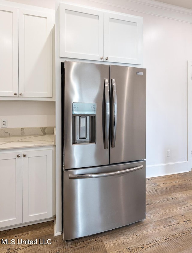 433 Main St, Natchez, MS 39120 - kitchen with stainless steel refrigerator with ice dispenser, white cabinetry, light wood-style floors, and light stone counters