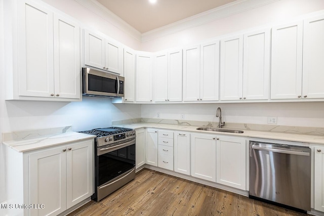 433 Main St, Natchez, MS 39120 - kitchen featuring stainless steel appliances, wood finished floors, crown molding, white cabinetry, and light stone countertops