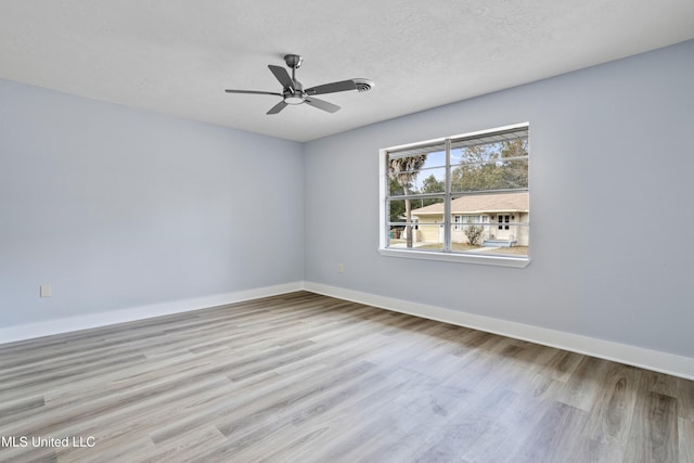 unfurnished room featuring ceiling fan, light hardwood / wood-style floors, and a textured ceiling