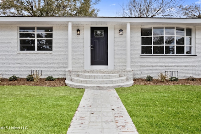 view of exterior entry with a lawn