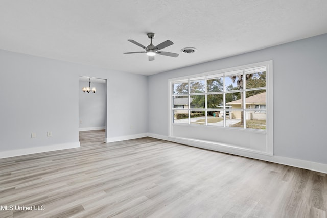 unfurnished room featuring ceiling fan with notable chandelier and light wood-type flooring