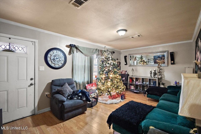 living room featuring wood-type flooring, a textured ceiling, and crown molding