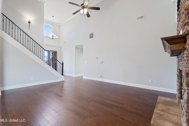 unfurnished living room featuring stairs, a stone fireplace, wood finished floors, and visible vents