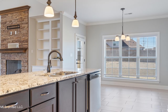 kitchen with gray cabinetry, a sink, a stone fireplace, light stone countertops, and dishwasher