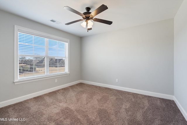 carpeted empty room featuring ceiling fan, visible vents, and baseboards