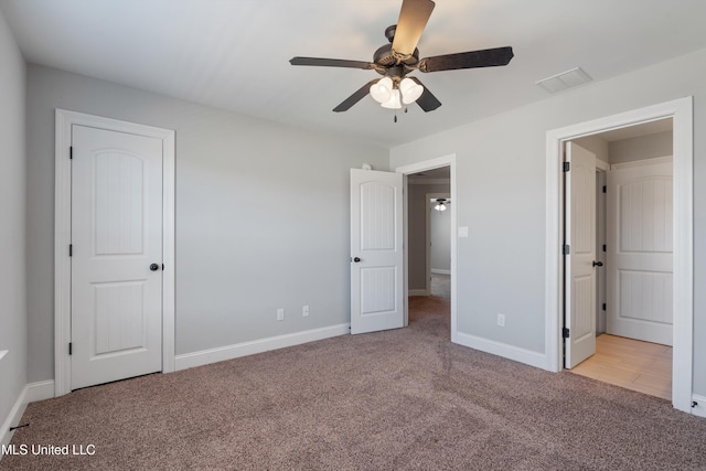 unfurnished bedroom with carpet floors, visible vents, and baseboards