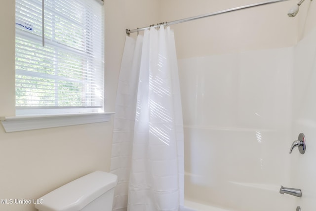 bathroom with shower / bath combination with curtain and toilet