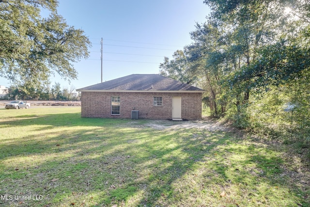 view of side of home with a lawn and central AC