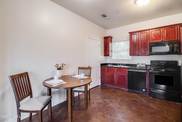 kitchen with black appliances, dark tile patterned floors, and sink