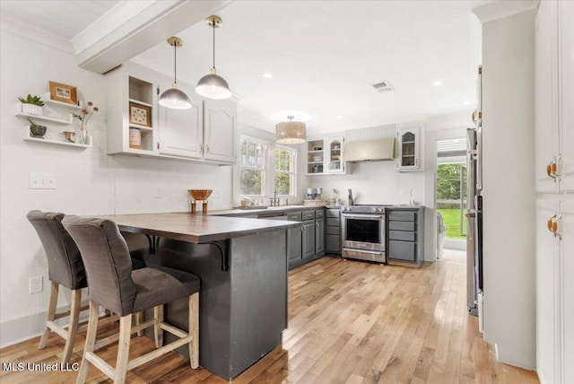7101 Wayne Ln, Biloxi, MS 39532 - kitchen with high end stainless steel range, premium range hood, a peninsula, plenty of natural light, and recessed lighting