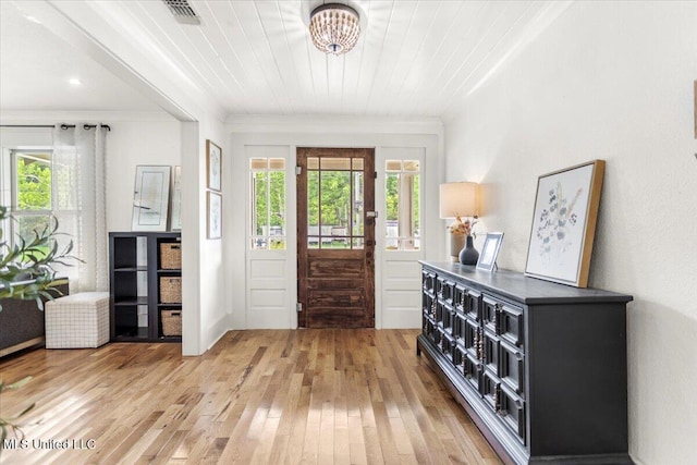 7101 Wayne Ln, Biloxi, MS 39532 - entrance foyer with light wood-style floors, crown molding, and a chandelier