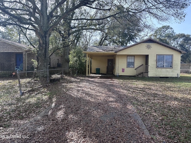 view of front facade with concrete block siding and fence