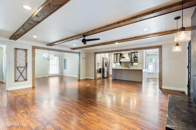 190 Briarwood Dr, Holly Springs, MS 38635 - unfurnished living room with beam ceiling, a chandelier, baseboards, healthy amount of natural light, and crown molding