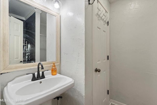 bathroom featuring crown molding and sink