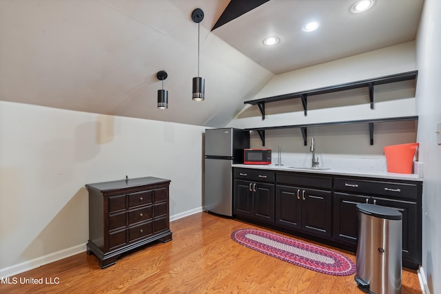 190 Briarwood Dr, Holly Springs, MS 38635 - indoor wet bar featuring freestanding refrigerator, light wood-type flooring, baseboards, lofted ceiling, and decorative light fixtures