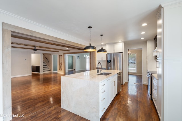 kitchen with white cabinets, stainless steel appliances, a kitchen island with sink, and sink