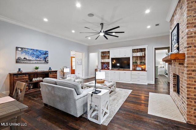 living room with ornamental molding, dark wood-type flooring, a fireplace, and ceiling fan