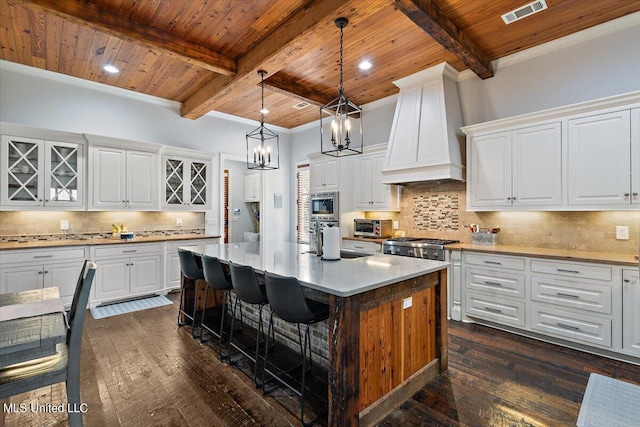 kitchen with a kitchen island, white cabinetry, custom range hood, and dark hardwood / wood-style flooring