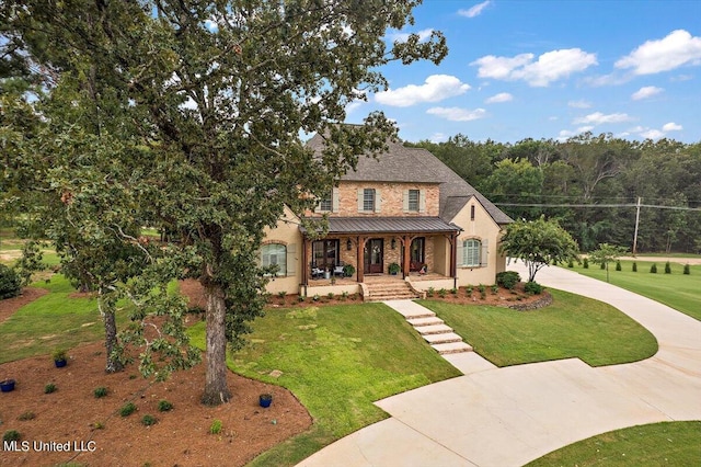 view of front of house with covered porch and a front lawn